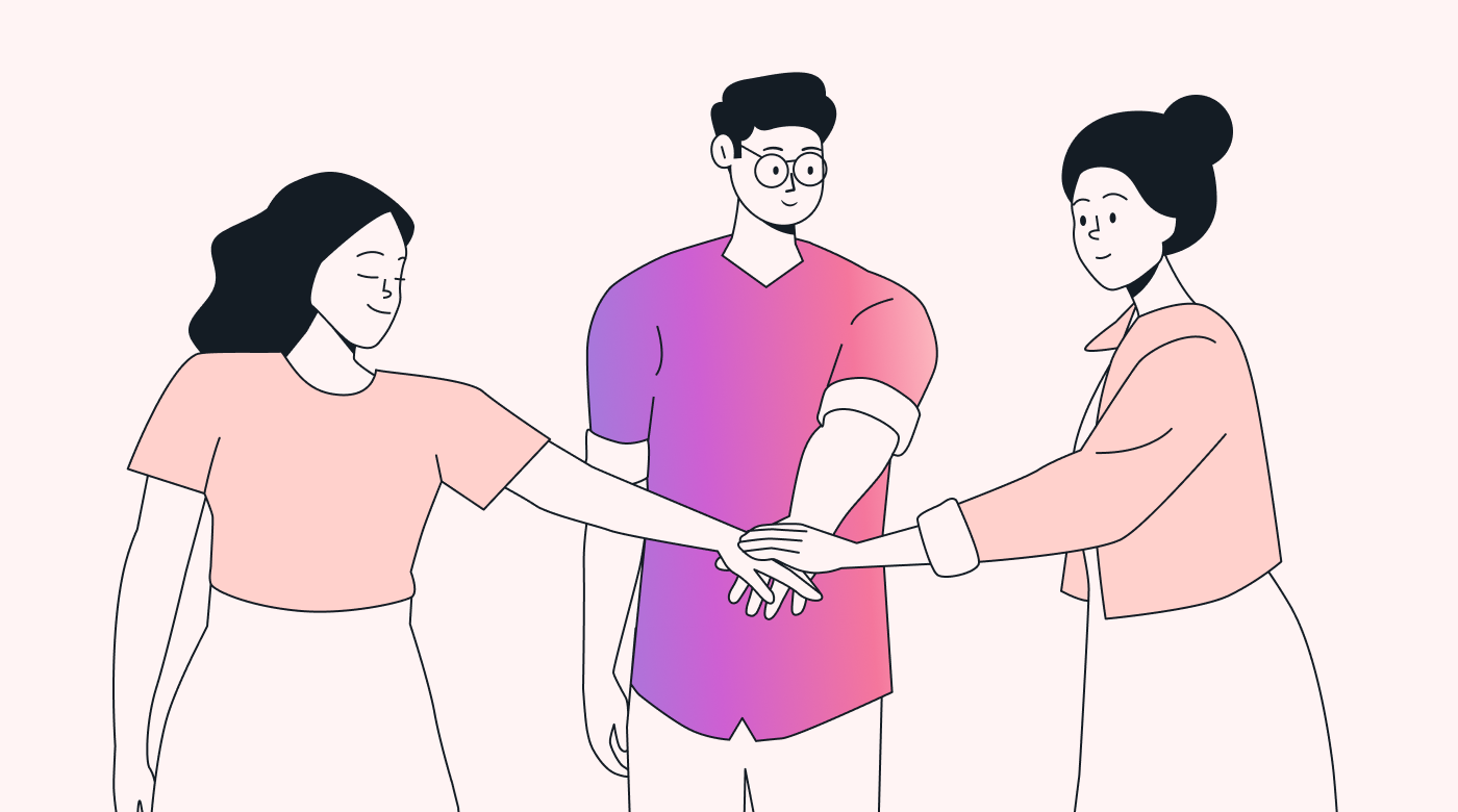 A team standing in a circle with each team member putting a hand in the middle of the circle
